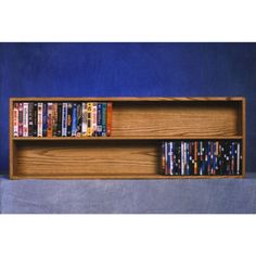 a wooden shelf with several dvd's on it and blue wall in the background