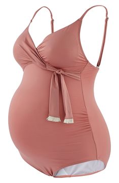 A gorgeous solid hue brings versatility to this one-piece swimsuit designed with ruched sides to flatter your changing figure. Adjustable shoulder straps that can be crossed at the back and a padded, sewn-in bra provide support throughout each trimester and beyond. Tassel-trimmed ties allow for discreet nursing access once baby arrives. 83% nylon, 17% elastane Machine wash, dry flat Imported Pink Ruched One-piece Swimwear, Fitted Maternity Swimwear For Summer, Pink Ruched Tankini For Pool, Pink Ruched Tankini For Poolside, Pink Ruched Tankini For Beachwear, Fitted Sleeveless Maternity Swimwear, Chic Pink Swimwear With Adjustable Straps, Spring Pink Ruched Tankini, Swimsuit Design