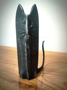 a black cat statue sitting on top of a wooden table