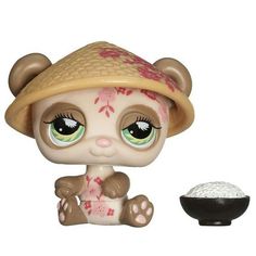 a little doll with big eyes sitting next to a bowl