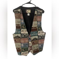 a vest made out of license plates is hanging on a hanger with a black shirt underneath it