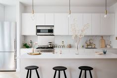 three stools are in front of the kitchen counter