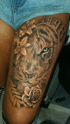 a woman's thigh with a tiger and roses on it