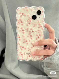 a person holding up a phone case with flowers on it