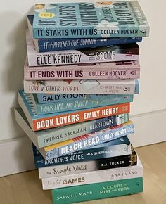 a stack of books sitting on top of a hard wood floor