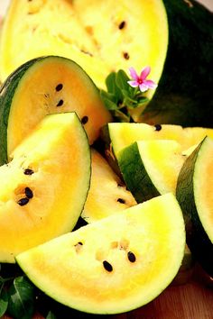 slices of melon on a cutting board with a flower in the middle and leaves around them