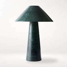 a green lamp sitting on top of a white table