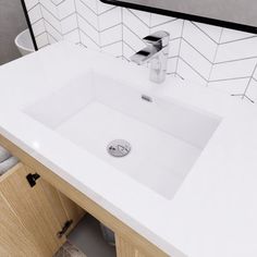 a bathroom sink sitting under a mirror next to a wooden cabinet and white tiled walls