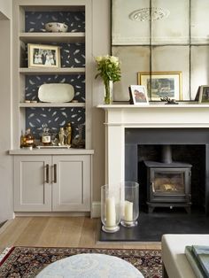 a living room filled with furniture and a fire place in front of a mirror on the wall