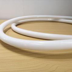 a close up of two white wires on a wooden surface