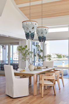 a dining room table with chairs and chandelier hanging from it's ceiling