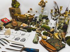 an assortment of tools are displayed on a table with other items in the background, including scissors and spoons