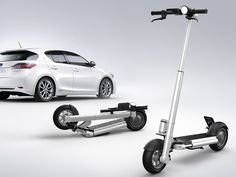 an electric scooter with two wheels and a car in the background