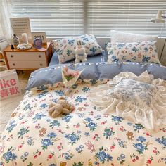 there is a teddy bear on the bed with pillows and blankets in front of it