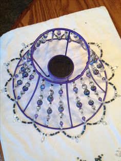 a solar powered device on top of a white table cloth with beads and crystals around it