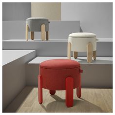 two stools sitting next to each other on top of a wooden floor in front of white and gray walls