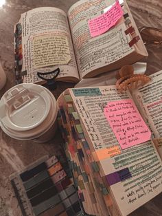 an open book sitting on top of a table next to a cup and other items