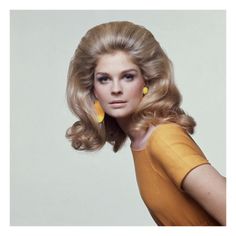 a woman with long blonde hair and yellow earrings on her head is posing for the camera