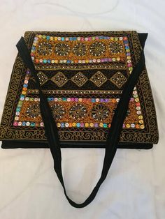 Handmade handbag... A colourful and unusual bag, handmade in the heart of pakistan sindh using original materials and traditional methods of patchworking and embroidery.. Traditional Multicolor Rectangular Shoulder Bag, Traditional Multicolor Square Shoulder Bag, Black Shoulder Bag For Festivals, Handmade Shoulder Bag With Multicolor Embroidery For Festivals, Bohemian Multicolor Bags With Zari Work, Handmade Multicolor Embroidered Shoulder Bag For Festivals, Rectangular Multicolor Embroidery Bag For Festivals, Black Rectangular Shoulder Bag For Festivals, Bohemian Multicolor Zari Work Bag