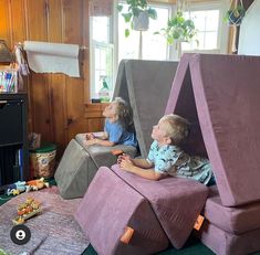 two young children sitting in chairs made to look like they're playing video games