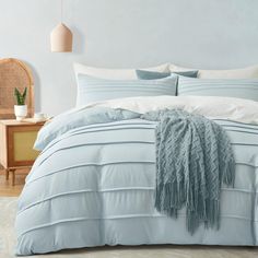 a bed with blue comforters and pillows in a room