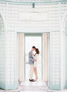 a man and woman standing in front of an open door with their arms around each other