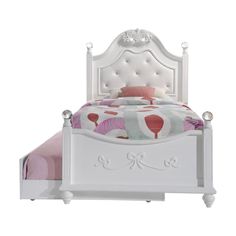 a white bed with pink and green bedspread on it's headboard