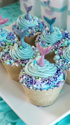 cupcakes with blue frosting and sprinkles on a plate