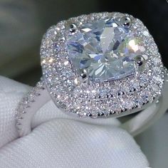 a cushion cut diamond surrounded by pave set diamonds