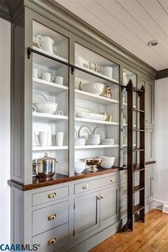 a large china cabinet with glass doors and shelves filled with dishes on top of it