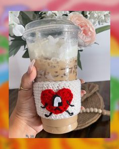 a hand holding a cup with coffee in it and the lid is crocheted