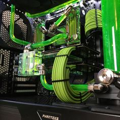 the inside of a computer case with green hoses