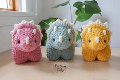 three small crocheted animals sitting on top of a table next to a potted plant