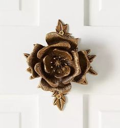 a gold flower brooch sitting on top of a white door