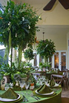 the table is set with green linens and place settings