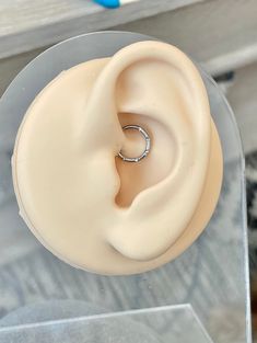 a close up of a fake ear with a ring on it