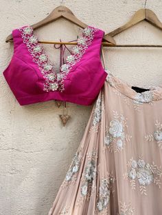 This gorgeous nude georgette umbrella lehenga with big sequin and thread work butti and gota work border is paired with a fuchsia raw silk blouse with mirror and thread work hand embroidery. The outfit is completed with a nude ruffled stole. Pink Embellished Silk Traditional Wear, Embellished Pink Silk Traditional Wear, Pink Silk Choli With Mirror Work, Silk Choli With Mirror Work For Party, Silk Lehenga With Mirror Work For Party, Elegant Pink Choli With Mirror Work, Embellished Pink Blouse Piece For Diwali, Pink Silk Choli For Parties, Pink Silk Choli For Party