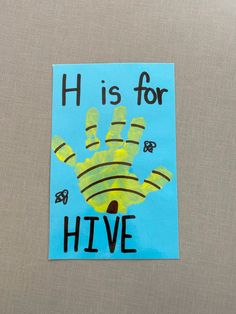 a piece of paper with the words h is for hive on it and a handprint