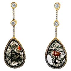 These brand-new Moss Agate Gemstone Diamond Drop Earrings in 18 karat white gold showcase the natural beauty of moss agate, with its unique earthy patterns, elegantly framed by sparkling diamonds. The earrings feature 2.21 carats of round brilliant-cut diamonds, adding a touch of luxury and brilliance. The diamonds are graded G-H color and VS clarity. Measuring 2.25 inches in length, these earrings offer a refined yet organic aesthetic, blending natural gemstones with the elegance of diamonds for a sophisticated, eye-catching accessory. Perfect for those who appreciate distinctive and luxurious designs. Weight: 15 grams. Earthy Patterns, Gold Diamond Drop Earrings, Earring Video, White Gold Drop Earrings, Yellow Gold Drop Earrings, Gray Gemstones, Diamond Chandelier, Organic Aesthetic, Yellow Quartz