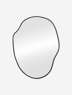 a round mirror on a white wall with a black border around the edges and an oval shape