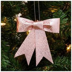 a pink bow ornament hanging from a christmas tree