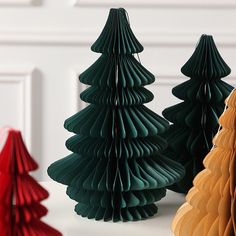 three paper christmas trees sitting next to each other