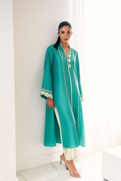 A long turqouise front open rawsilk kurta features printed applique and pleated details. Adorned with delicate embroidery on scalloped sleeves, the kurta is paired with a floral printed rawsilk shalwar. Model Height is 5'7 and Shirt length is 48" Chanderi Kurta With Embroidered Long Sleeves, Designer Anarkali Kurta With Embroidered Sleeves, Festive Straight Kurta With Embroidered Sleeves, Anarkali Cotton Silk Kurta For Spring, Spring Anarkali Cotton Silk Kurta, Bollywood Style Kurta For Diwali With Embroidered Sleeves, Diwali Salwar Kameez With Embroidered Sleeves, Festive Salwar Kameez With Embroidered Sleeves And Straight Kurta, Festive Salwar Kameez With Straight Kurta And Embroidered Sleeves