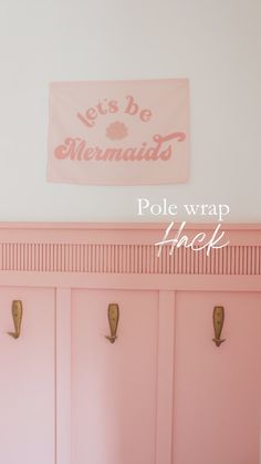 a pink bathroom with gold handles on the wall and a sign that says, let's be mermaids