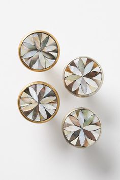 three pairs of gold and white diamond studs on top of each other in front of a white background