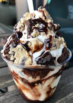 an ice cream sundae with chocolate chunks and marshmallows in a plastic cup