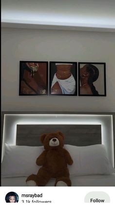 a teddy bear sitting on top of a bed next to two pictures above the headboard