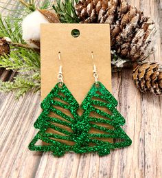 Glitter Christmas Tree Earrings, perfect for the holiday season! Sparkly and festive and they come in your choice of color. Our earrings are made with hand poured resin and tons of glitter! They are lightweight and easy to wear all day.  They measure approximately 2 inches long.  The posts are stainless steel and are hypoallergenic.  Your earrings will come on a card and in a drawstring pouch. They are ready to give as a gift or to throw in a stocking! Be sure to check out all of our other unique and fun items. Green Glitter Earrings As A Gift, Holiday Party Earrings With Ear Wire, Holiday Winter Drop Earrings, Green Drop Earrings For Holiday, Winter Holiday Drop Earrings, Winter Party Dangle Jewelry, Silver Earrings For Holiday Parties, Christmas Drop Earrings For Celebration, Winter Festive Dangle Earrings