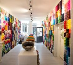 a room with many different colored fabrics on the walls and in front of it is a sculpture