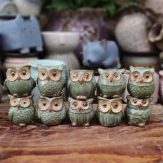 a group of ceramic owls sitting on top of a wooden table